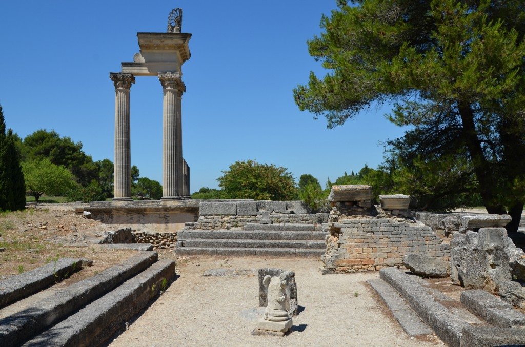 The Hellenistic Bouleteurion with the partially reconstructed temple in the background, Glanum © Carole Raddato